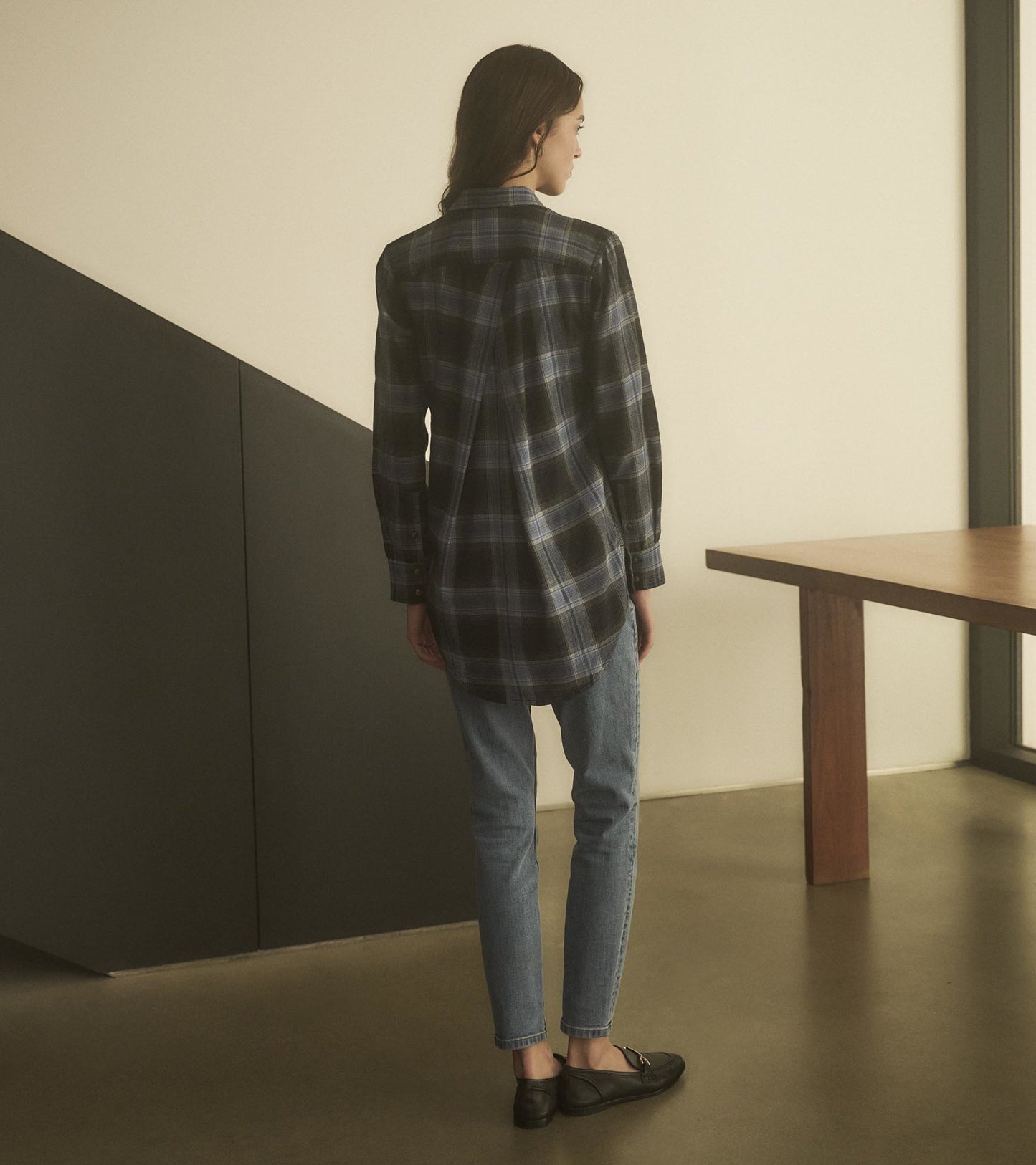 Long-sleeve tunic in caviar plaid, featuring a curved hem and relaxed fit, paired with light blue jeans and black shoes.