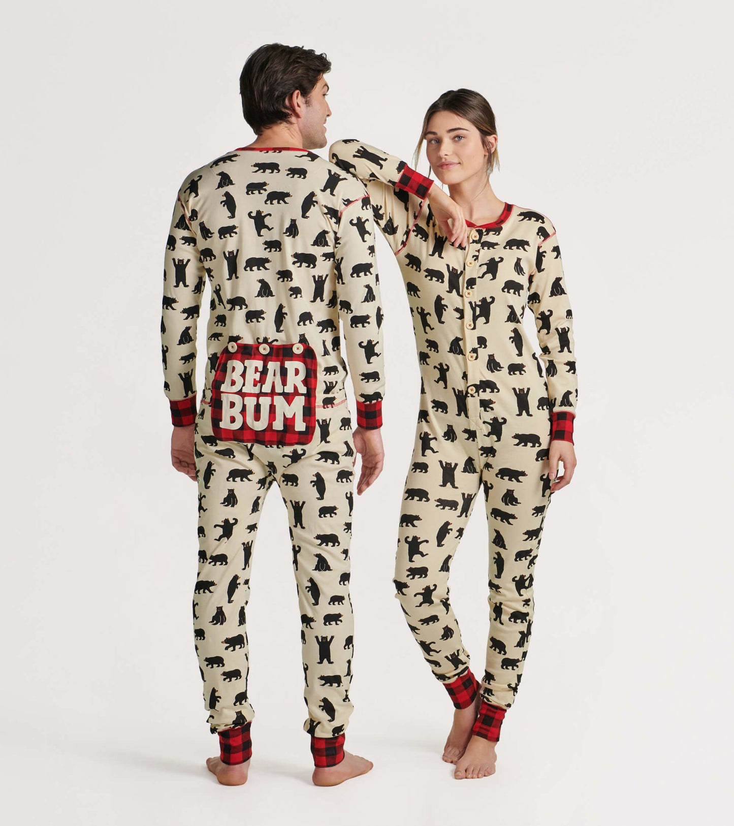 Cream-colored adult onesie featuring black bear prints and red plaid accents, with a playful "BEAR BUM" design on the back.