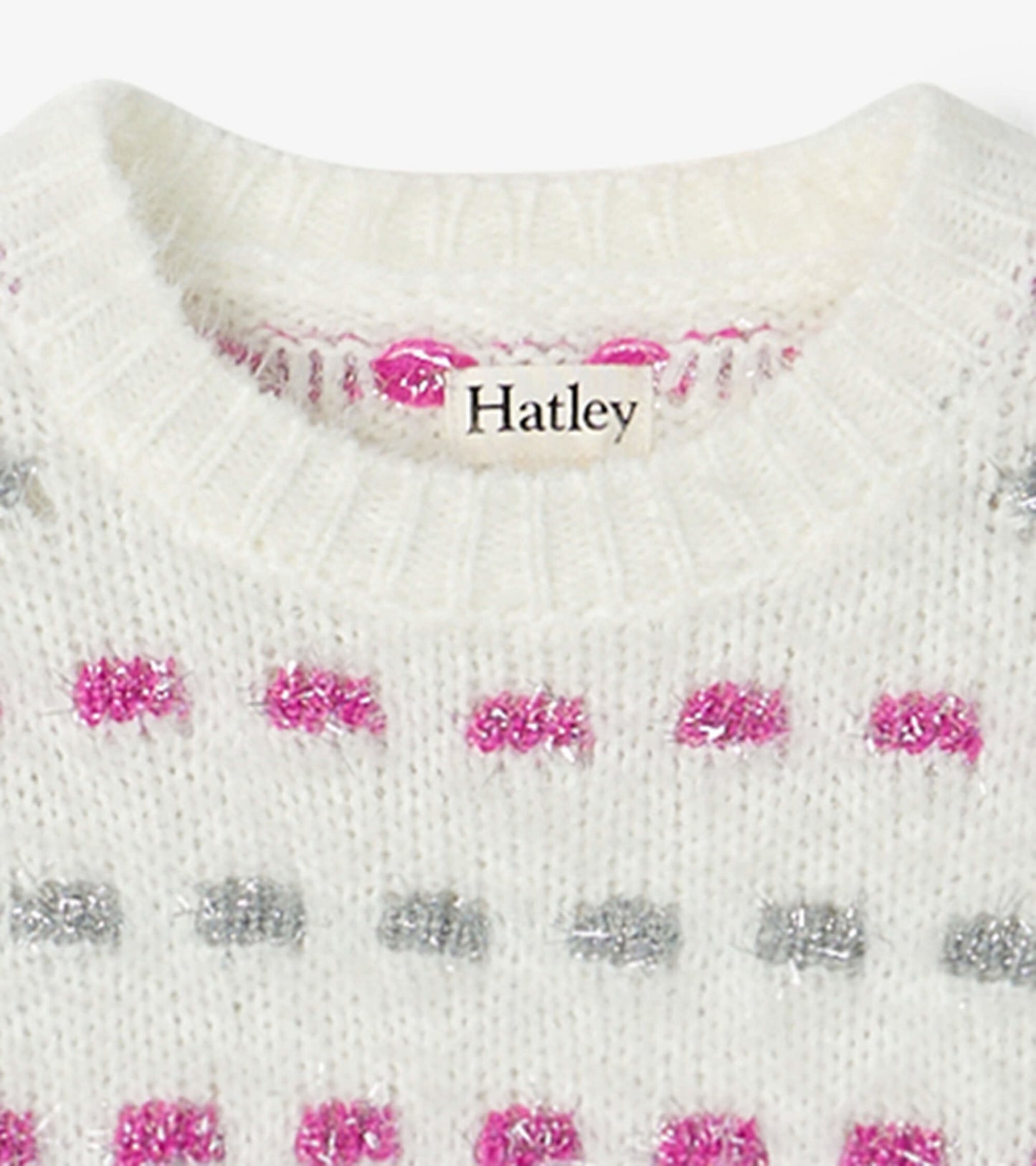 White sweater tunic featuring a basket weave pattern with pink and silver dots, round neckline, and ribbed cuffs.