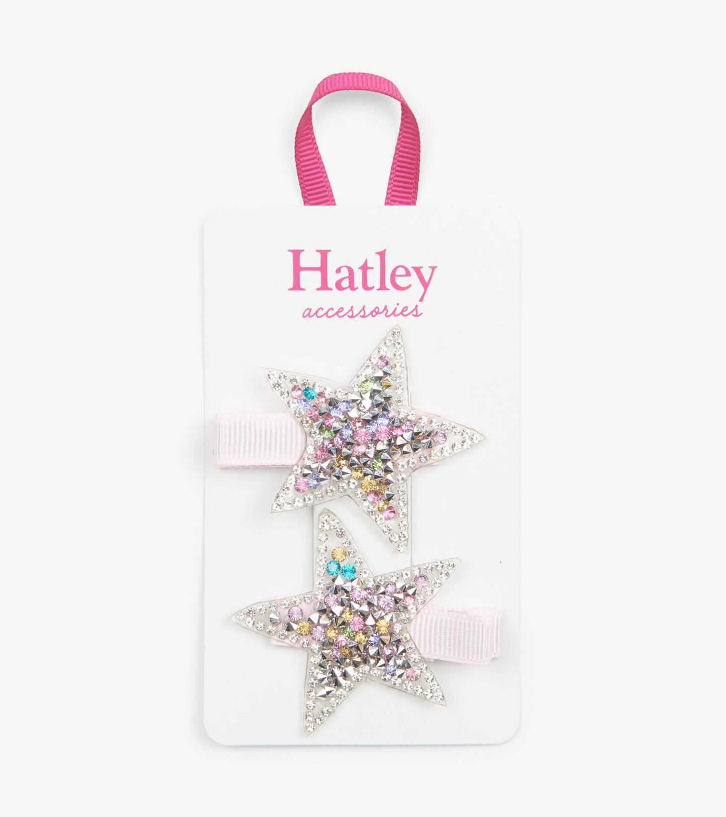 Two star-shaped hair clips with colorful rhinestones on a pink ribbon, displayed on a card.
