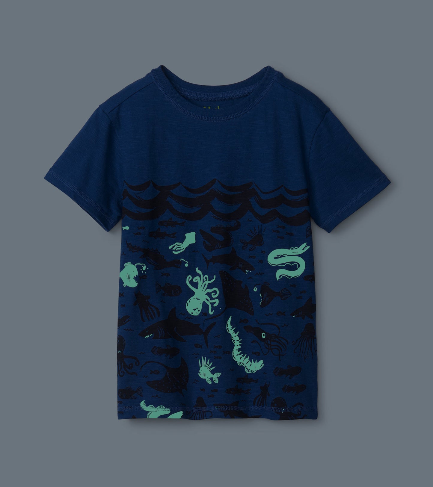 Navy blue graphic tee featuring glow-in-the-dark sea creatures and waves pattern, short sleeves, and crew neck.