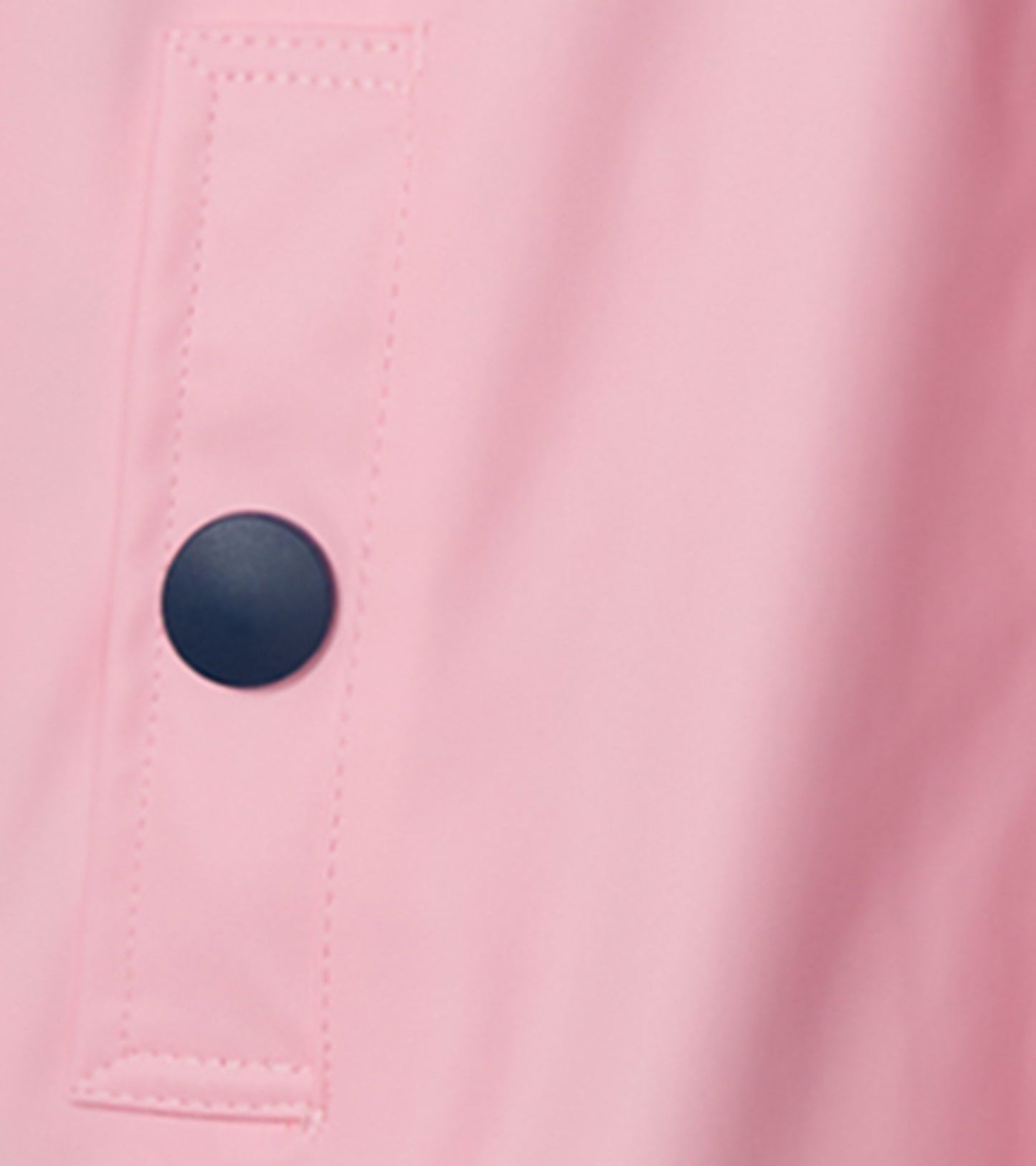 Pink rain jacket featuring a navy button and stitched detailing. Suitable for girls, ideal for wet weather.