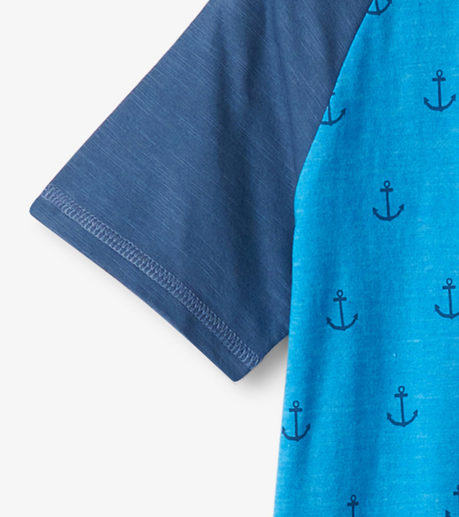 Blue raglan t-shirt featuring a nautical anchor pattern on the body and solid navy sleeves.