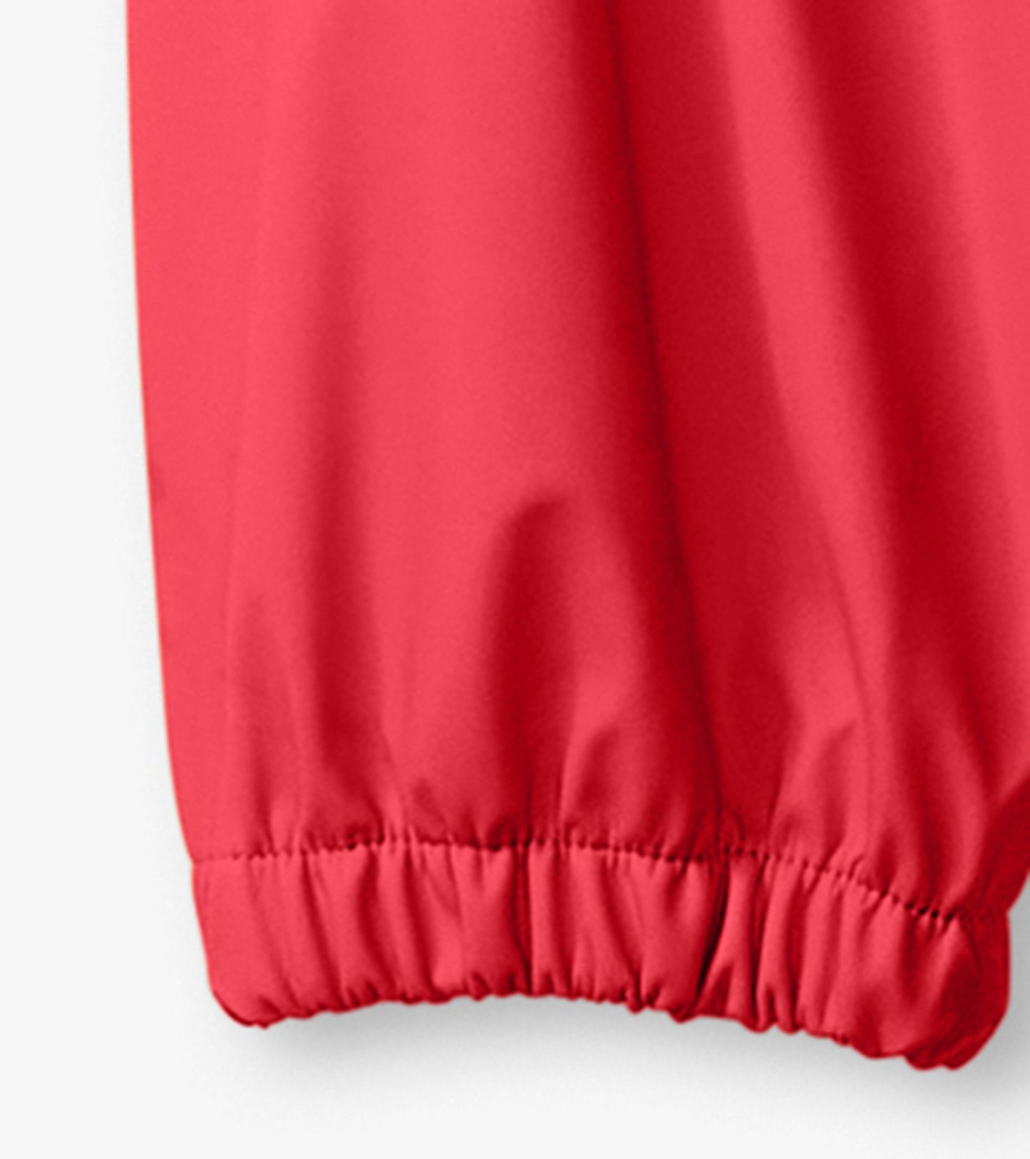 Bright red rain pants for kids with elastic cuffs, designed for outdoor play in wet weather.