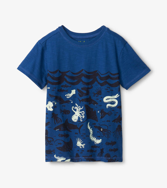 Blue graphic tee featuring ocean-themed designs with sea creatures and waves, made from soft fabric.