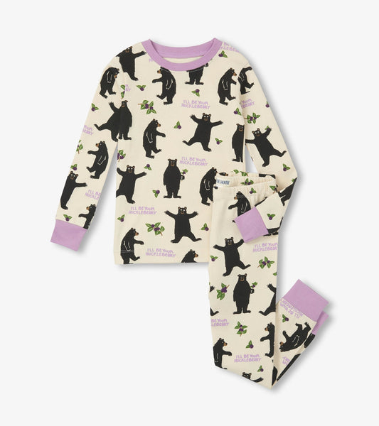 Cream-colored kids' pajama set featuring playful black bear and leaf patterns, with lavender cuffs on the top and pants.
