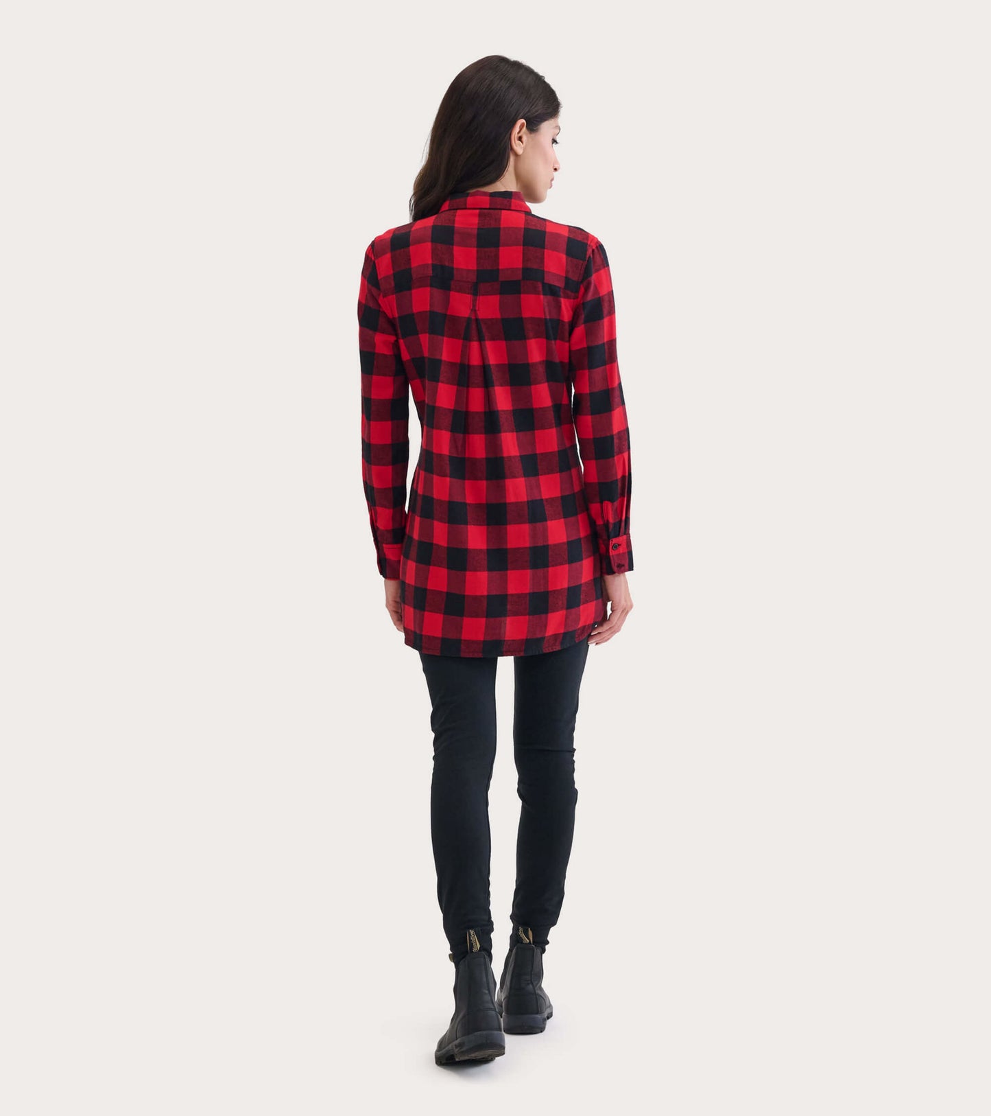 Red and black plaid flannel tunic with long sleeves, featuring a buttoned collar and a relaxed fit, worn with black leggings.