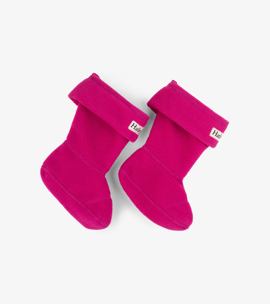 Magenta fleece boot liners with a fold-over cuff, designed for kids in various sizes.