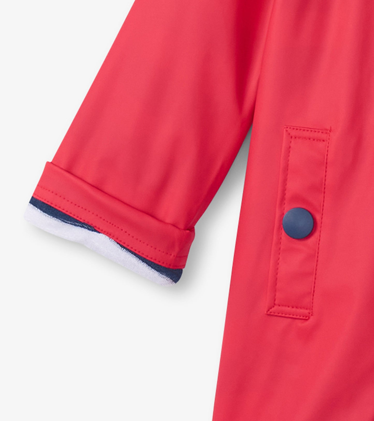 Red rain jacket with navy trim, featuring a button closure and a soft lining at the cuffs. Ideal for kids.