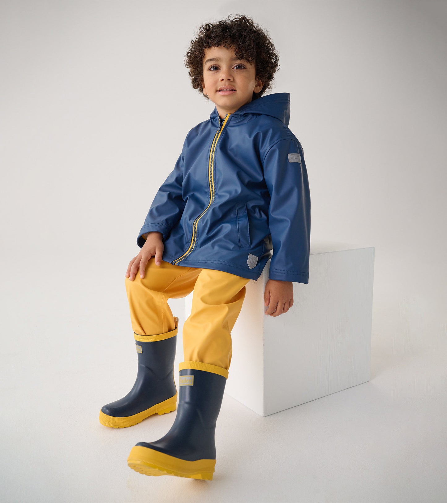 Navy blue and yellow matte rain boots for kids, featuring a sturdy design and a comfortable fit.