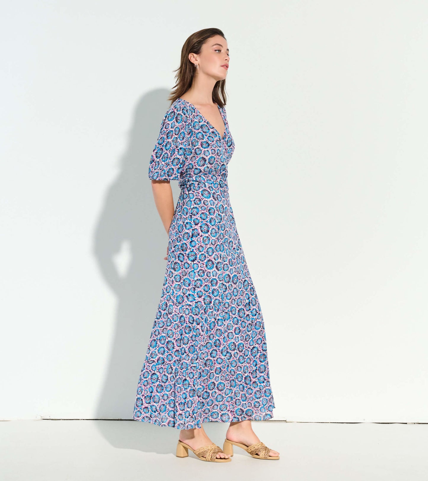 Maxi dress featuring a sundial mandala pattern in blue, pink, and white, with a v-neck and puff sleeves.