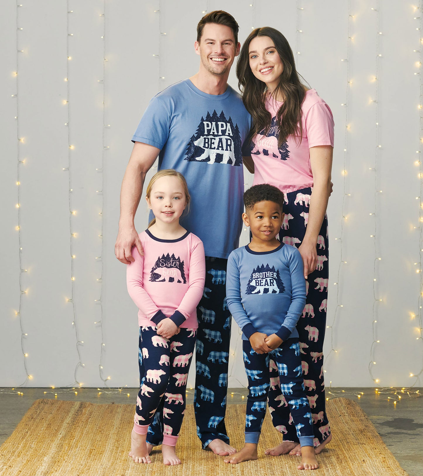 Kids' pajama set featuring pink and blue tops with bear graphics and coordinating patterned pants in navy.