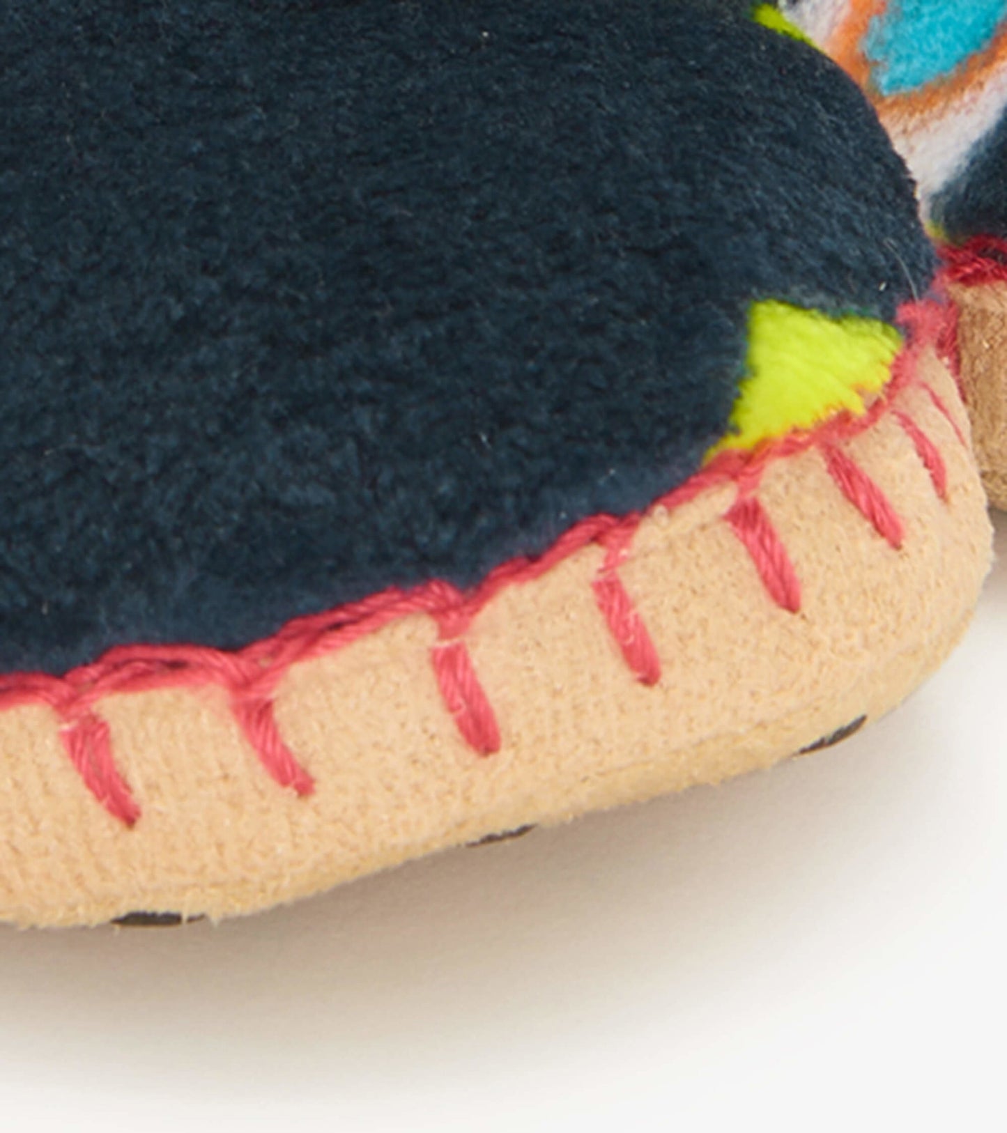Navy fleece kids' slippers with colorful accents and stitched detailing on the sole for comfort and warmth.