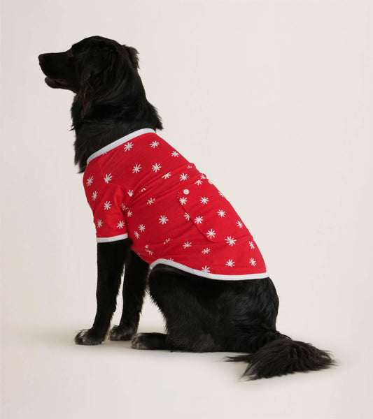 Red dog tee featuring white snowflake patterns, designed for winter wear, shown on a sitting dog.