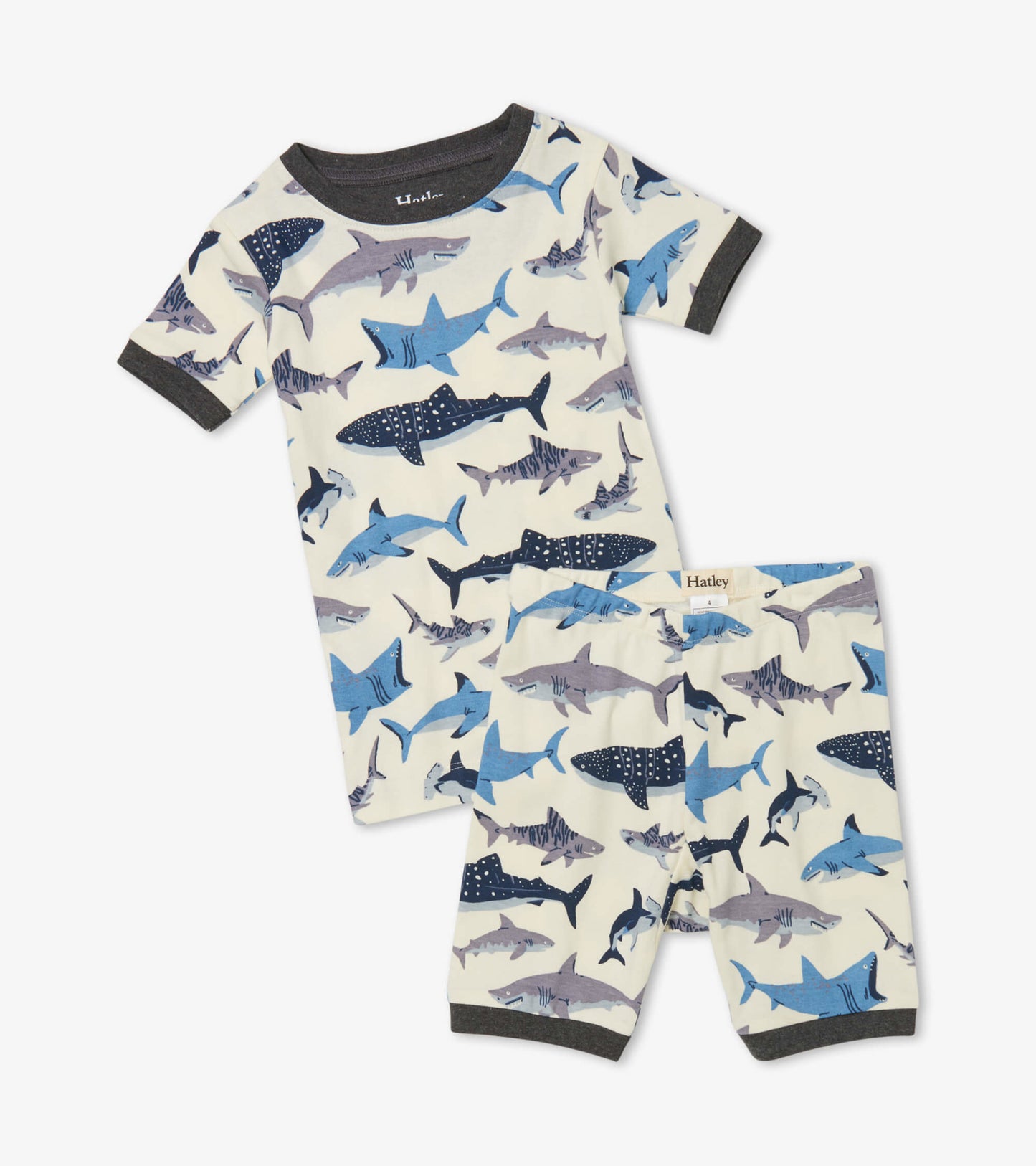 Organic cotton short pajama set featuring a playful shark print in blue and gray on a cream background.