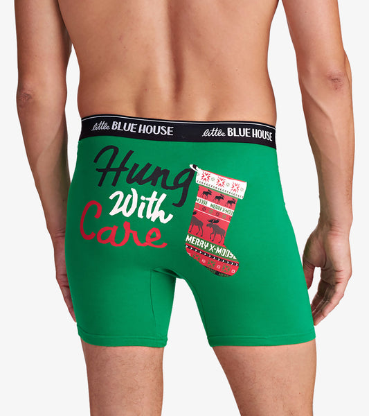 Green boxers featuring a festive design with the text "Hung With Care" and a Christmas stocking graphic.