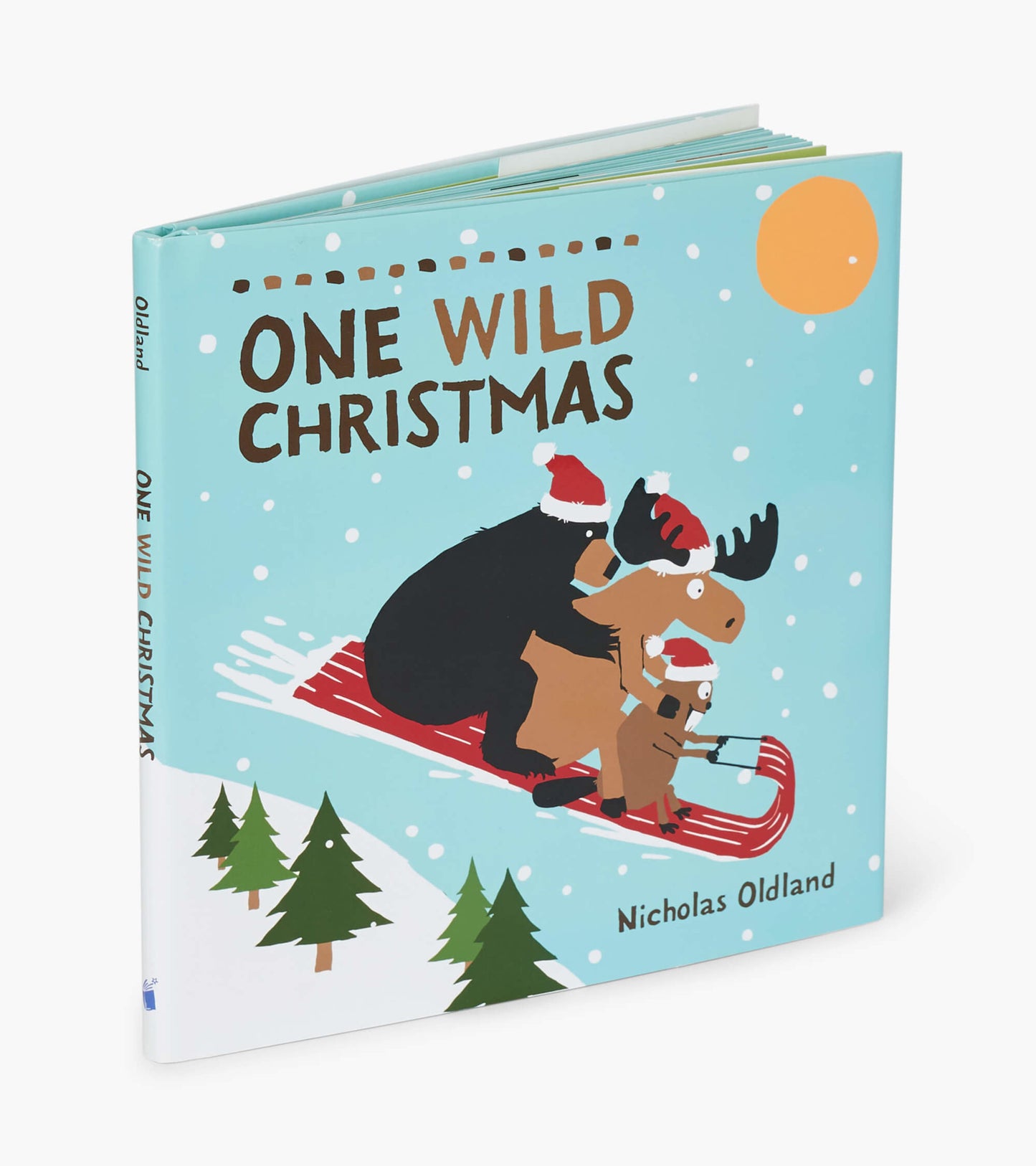 Colorful children's book featuring a bear and moose in Santa hats sledding in a snowy landscape with trees.
