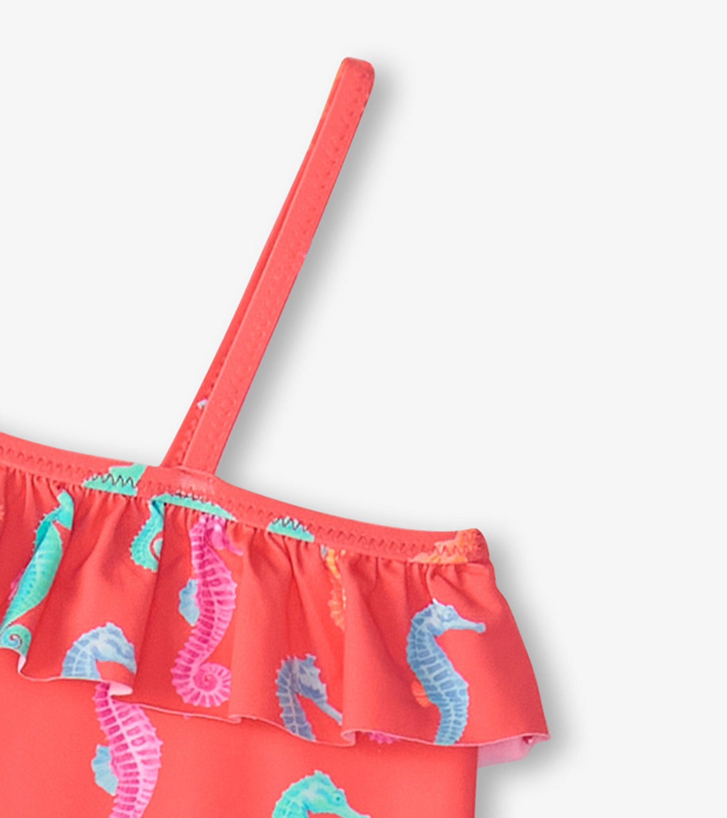 Coral swimsuit with colorful seahorse print and ruffle trim, featuring a single shoulder strap.