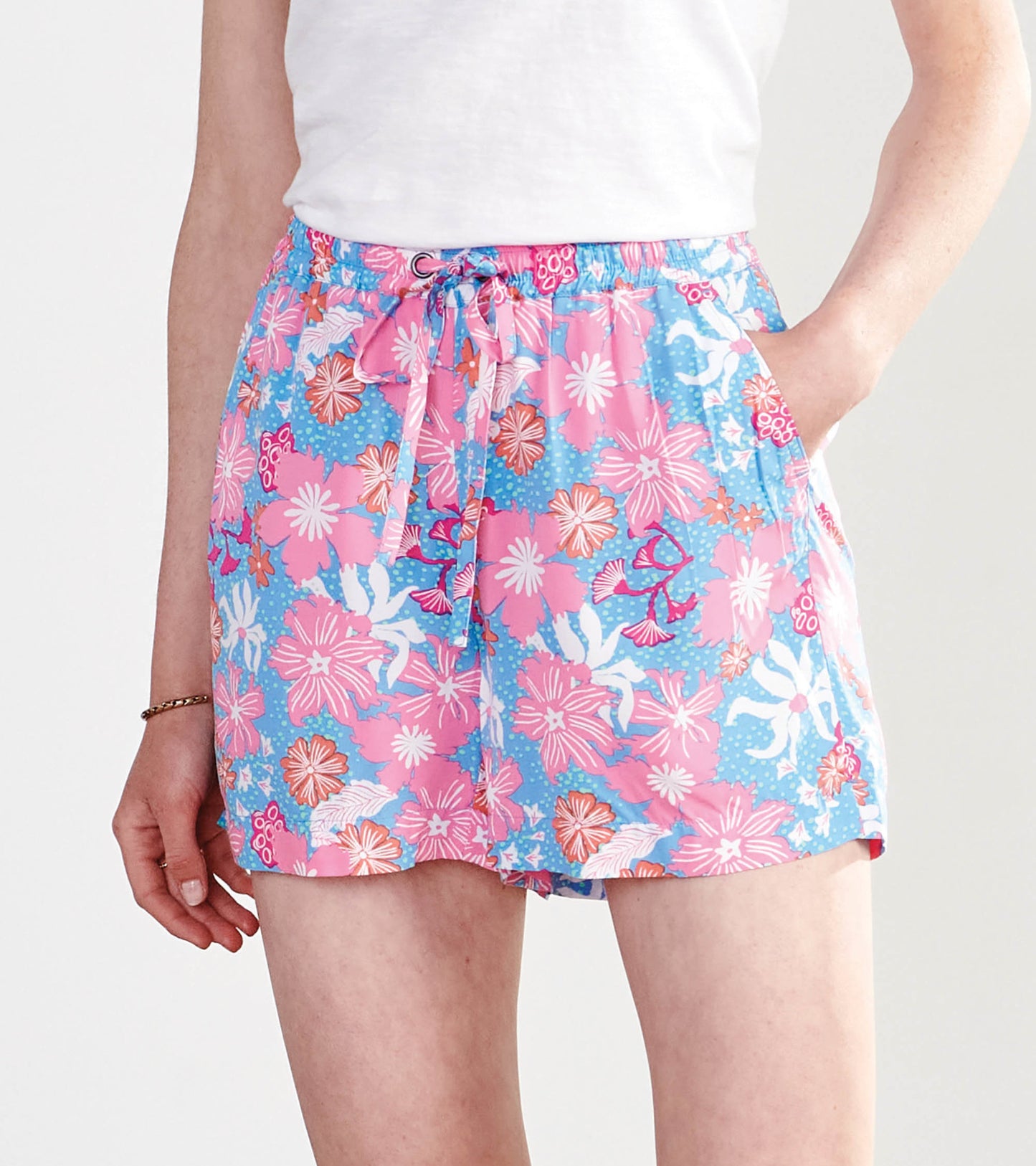 Colorful floral shorts featuring a pink and blue pattern, elastic waistband with drawstring, and side pockets.