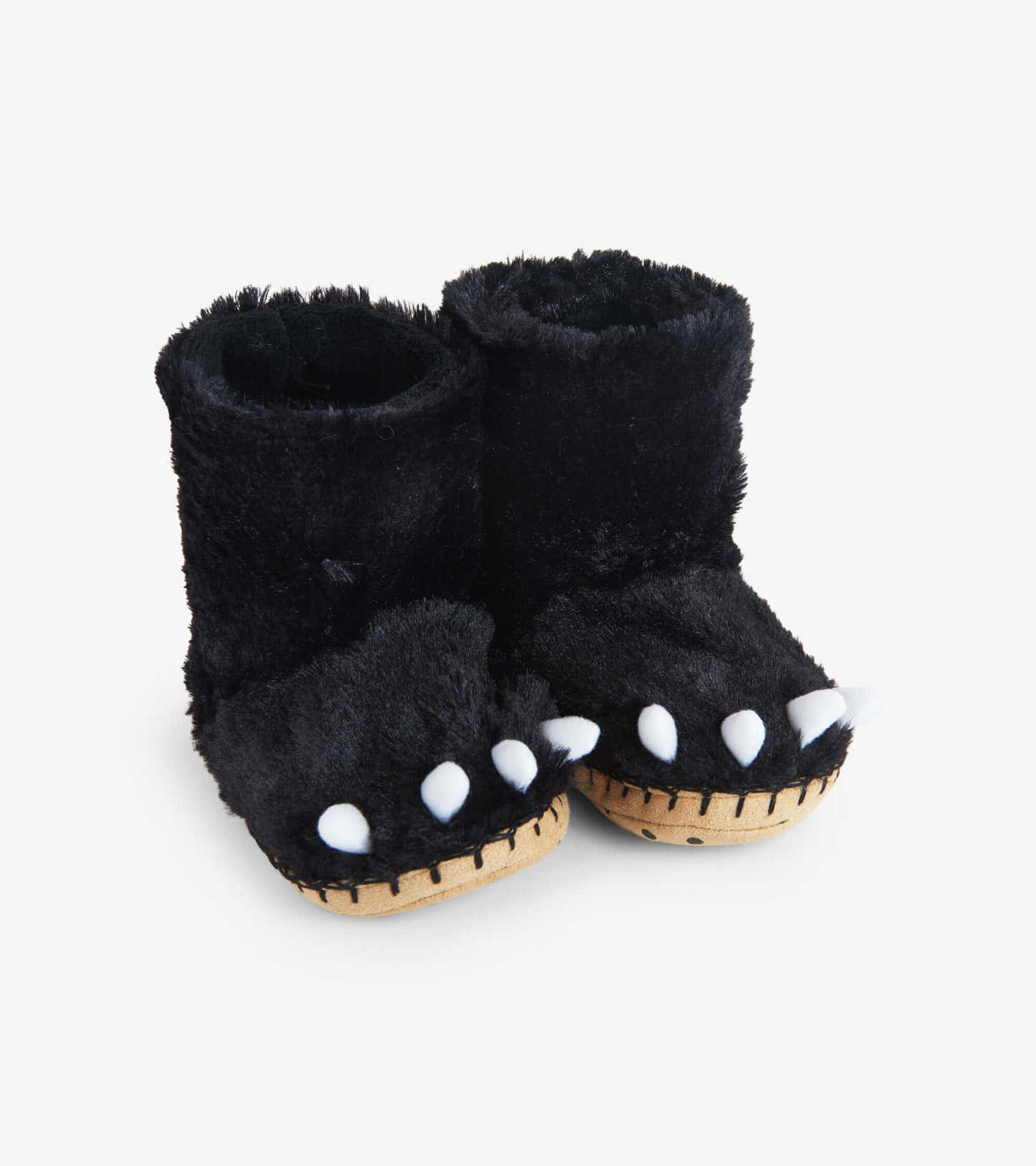 Black fuzzy slouch slippers shaped like bear paws with white claws and a soft lining, suitable for kids.