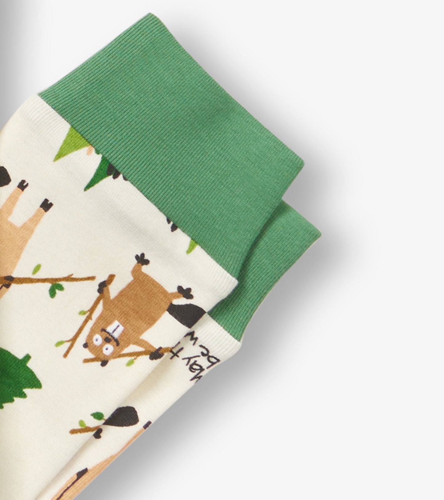 Kids pajama set featuring a cream base with playful animal and tree patterns, accented by green ribbed cuffs.