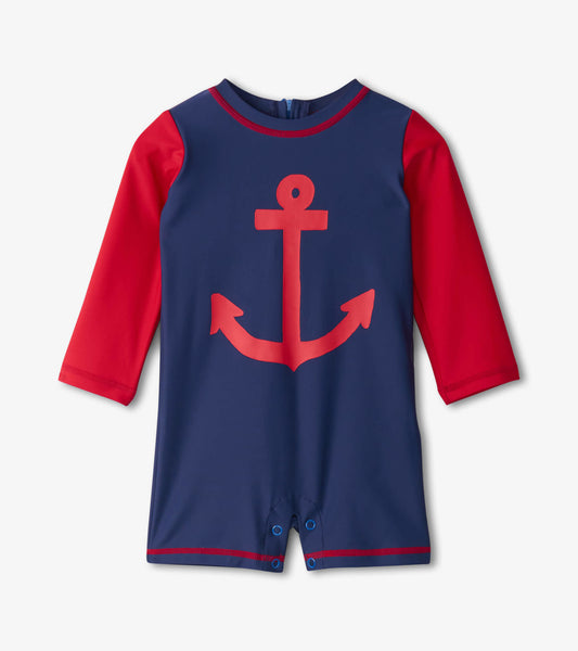 Navy one-piece rashguard with red sleeves and a large red anchor graphic, featuring snap closures at the bottom.