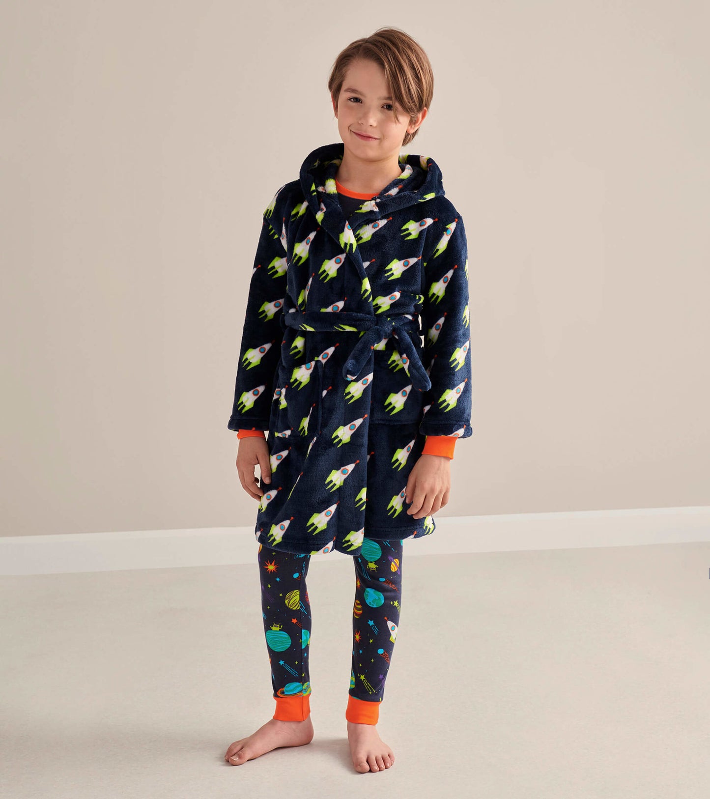 Navy fleece robe with rocket pattern, featuring an orange trim, worn by a child over space-themed leggings.