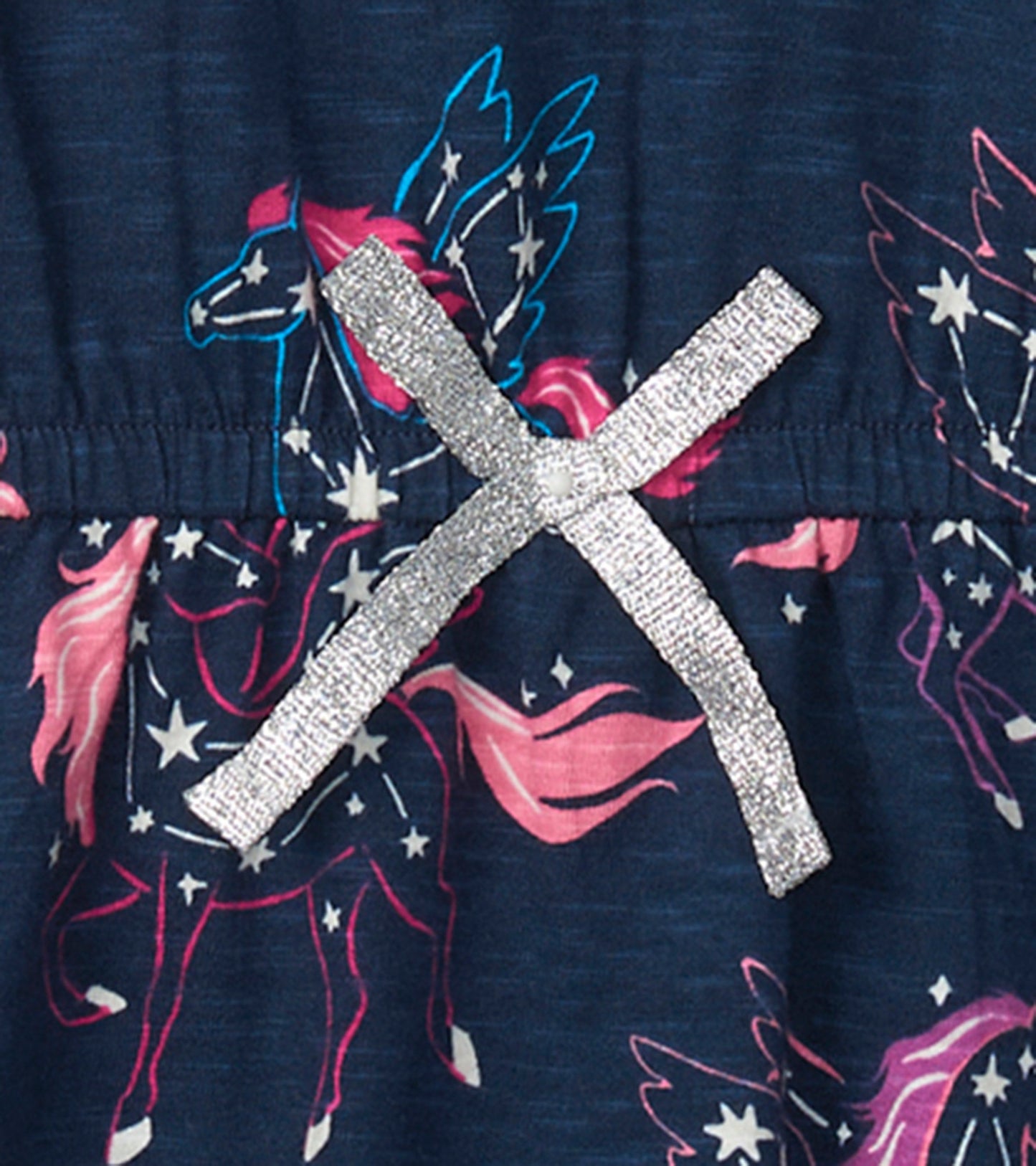Navy dress featuring colorful pegasus and star print, with a silver ribbon detail at the waist.