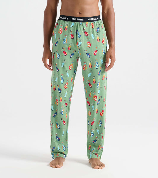 Green pajama pants featuring a playful pattern of golf bags and clubs, with an elastic waistband labeled "MAN PANTS.