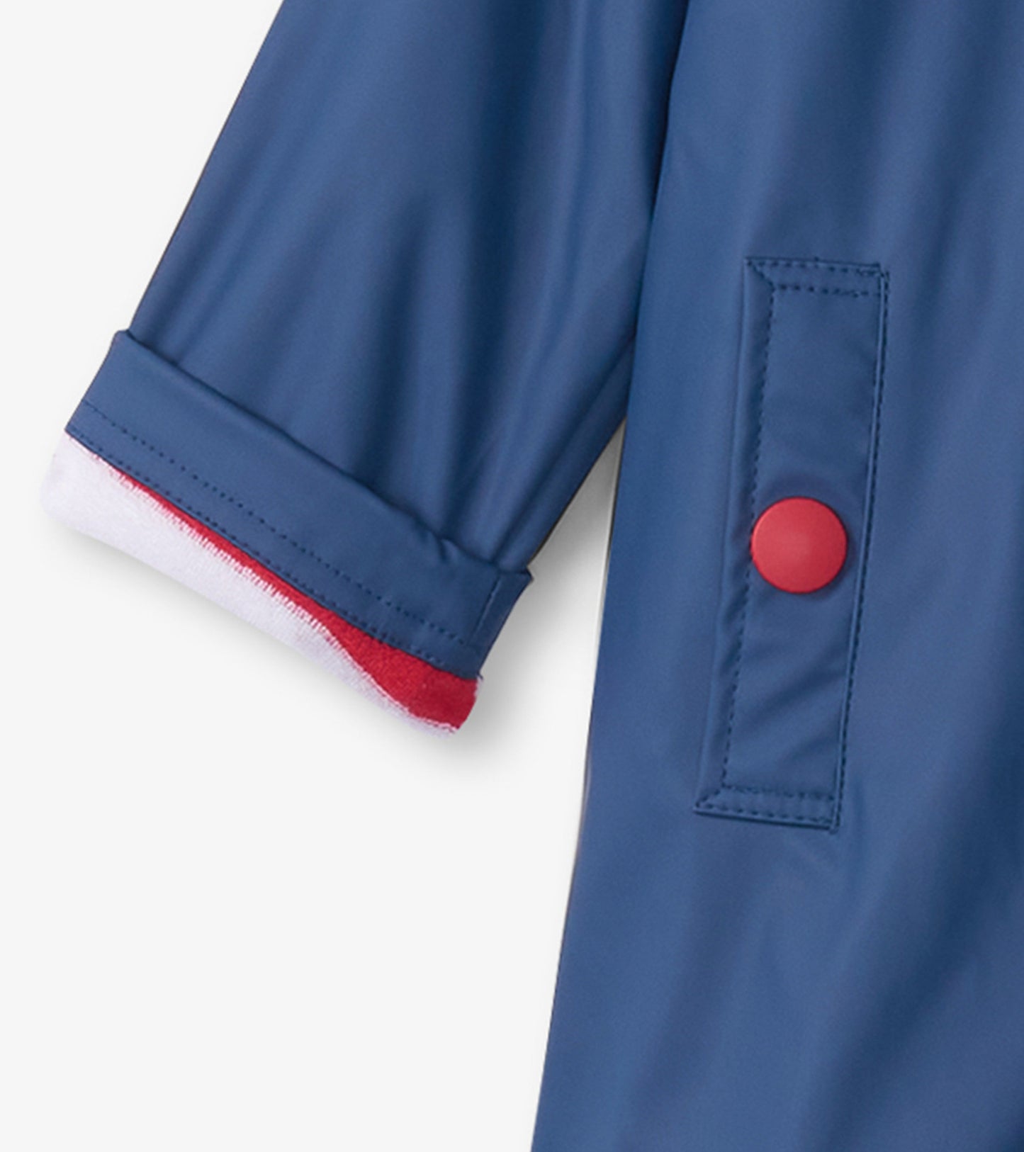 Navy rain jacket with red button and contrasting red and white cuff, designed for kids.