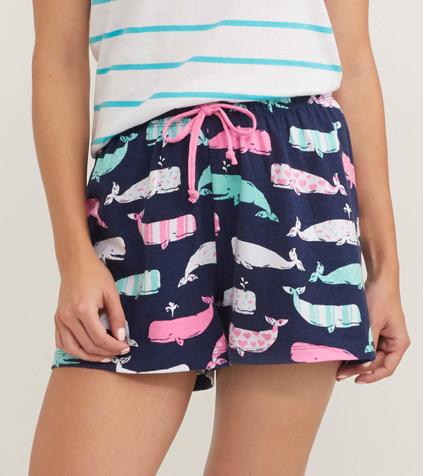 Navy cotton sleep shorts featuring a playful whale pattern in pink and teal, with an elastic waistband and drawstring.