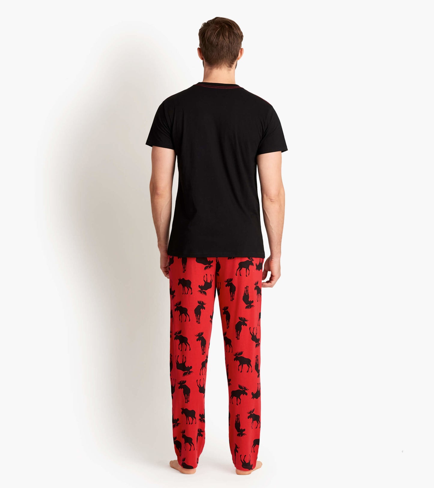 Red stretch cotton pajama pants featuring a black moose pattern, shown from the back with a black t-shirt.