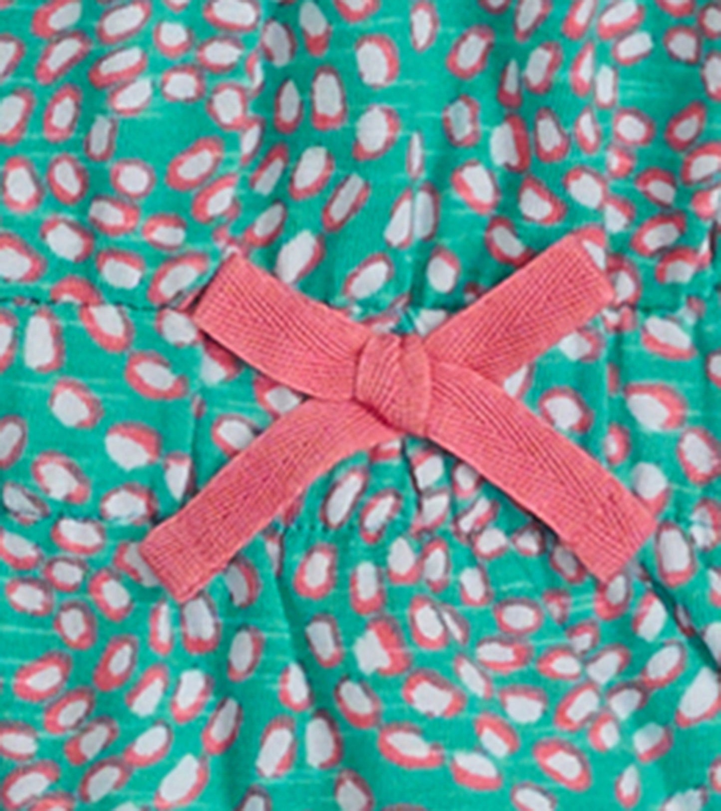 Turquoise dress with pink and white pebble pattern, featuring a pink bow detail at the waist.