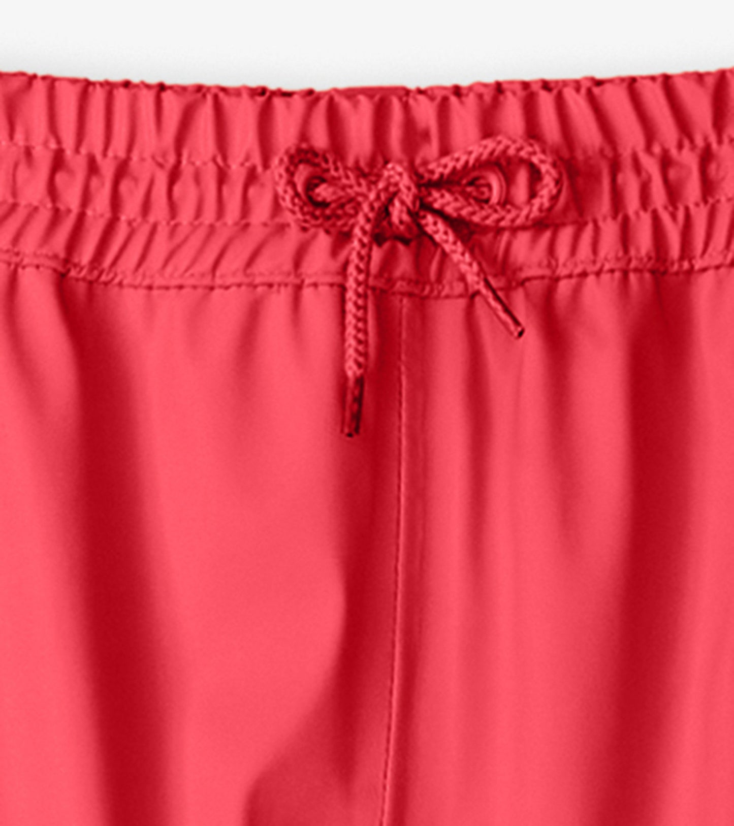 Bright red kids' rain pants with an elastic waistband and adjustable drawstring. Suitable for wet weather activities.