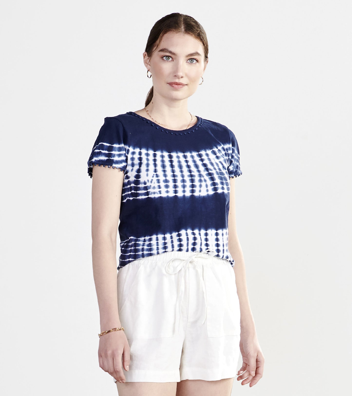 Navy blue tie-dye short-sleeve tee with a round neckline, paired with white shorts.
