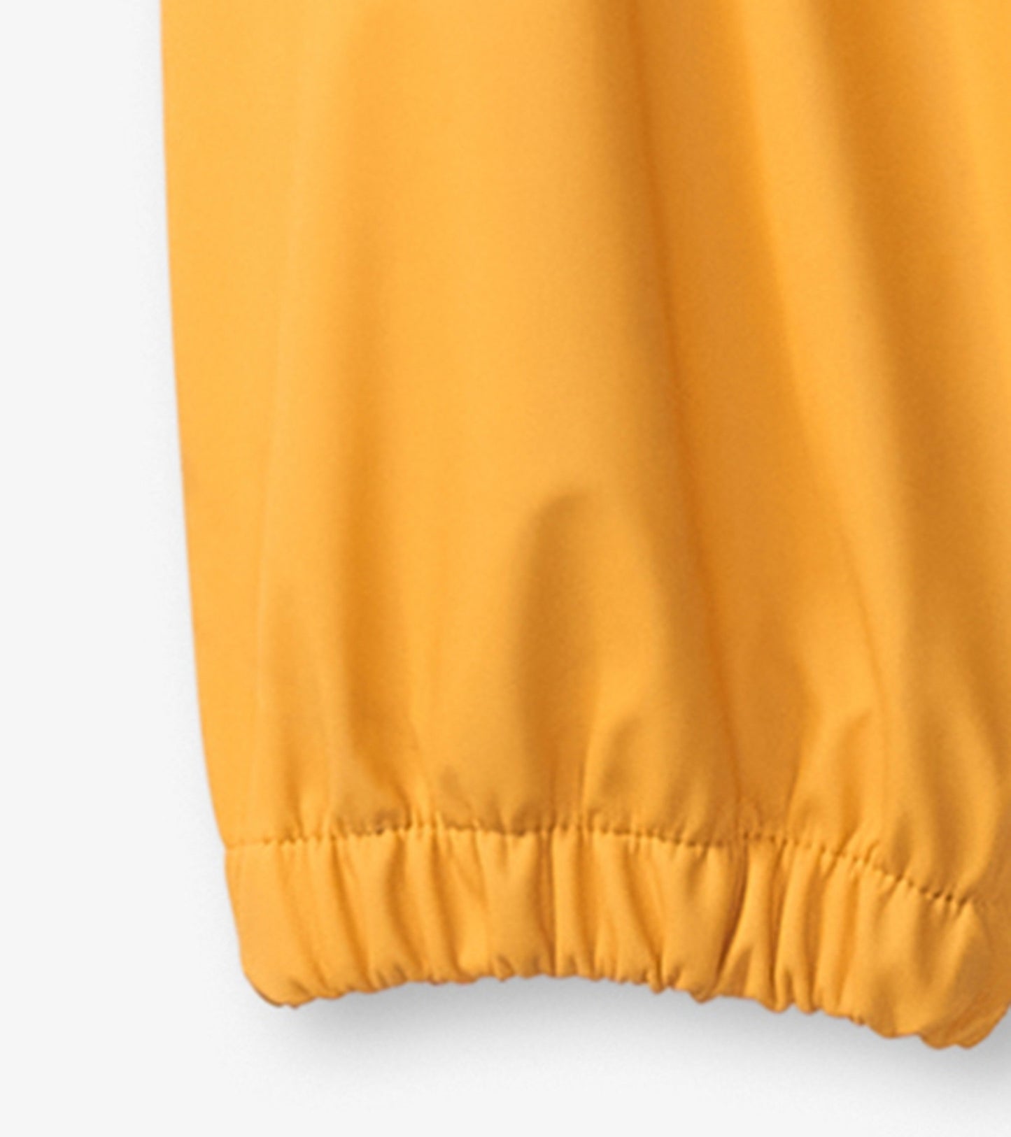 Yellow waterproof rain pants with elastic cuffs, designed for kids, suitable for outdoor play in wet weather.