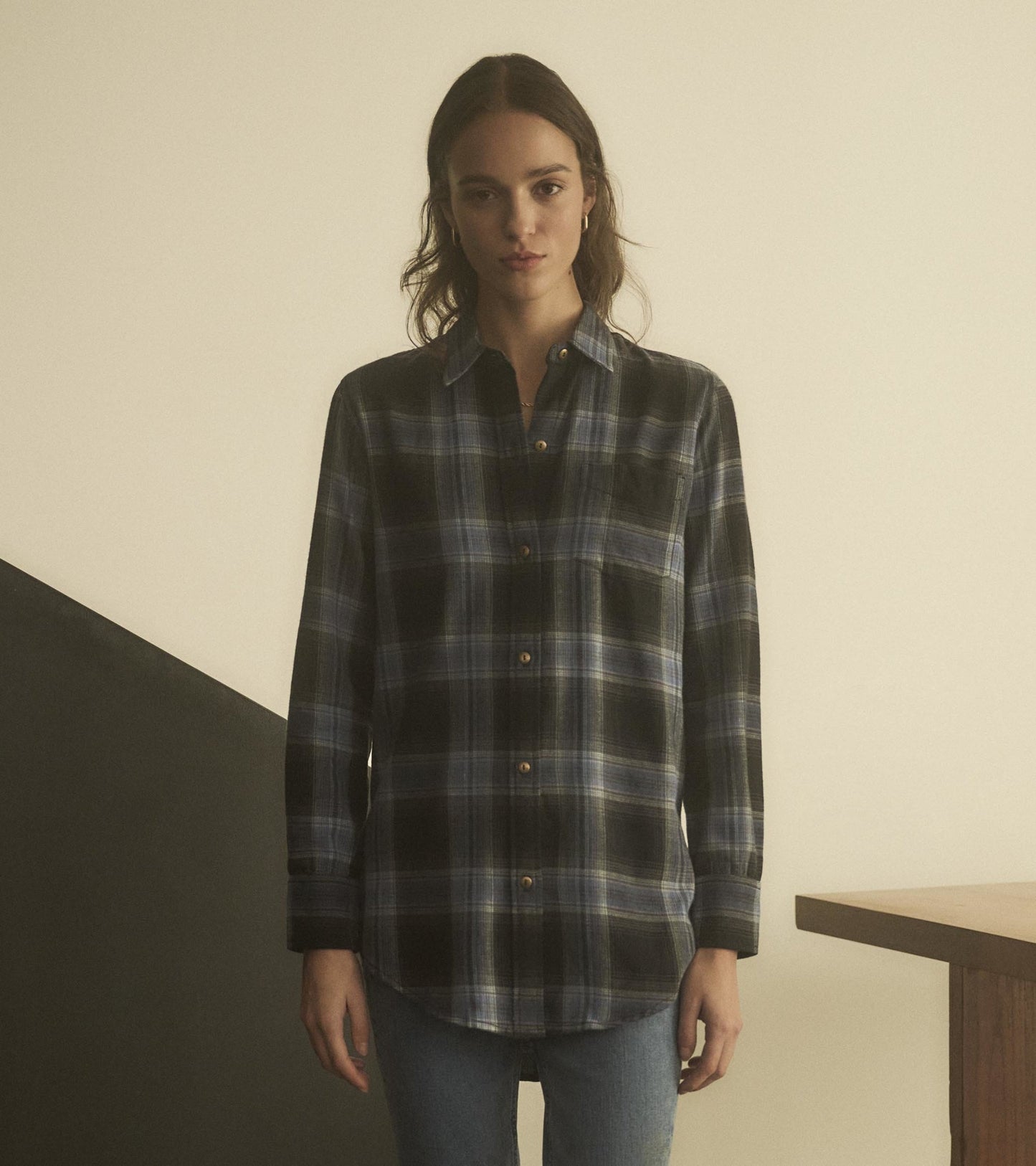 Black and blue plaid tunic with a button-down front and long sleeves, styled with a relaxed fit.