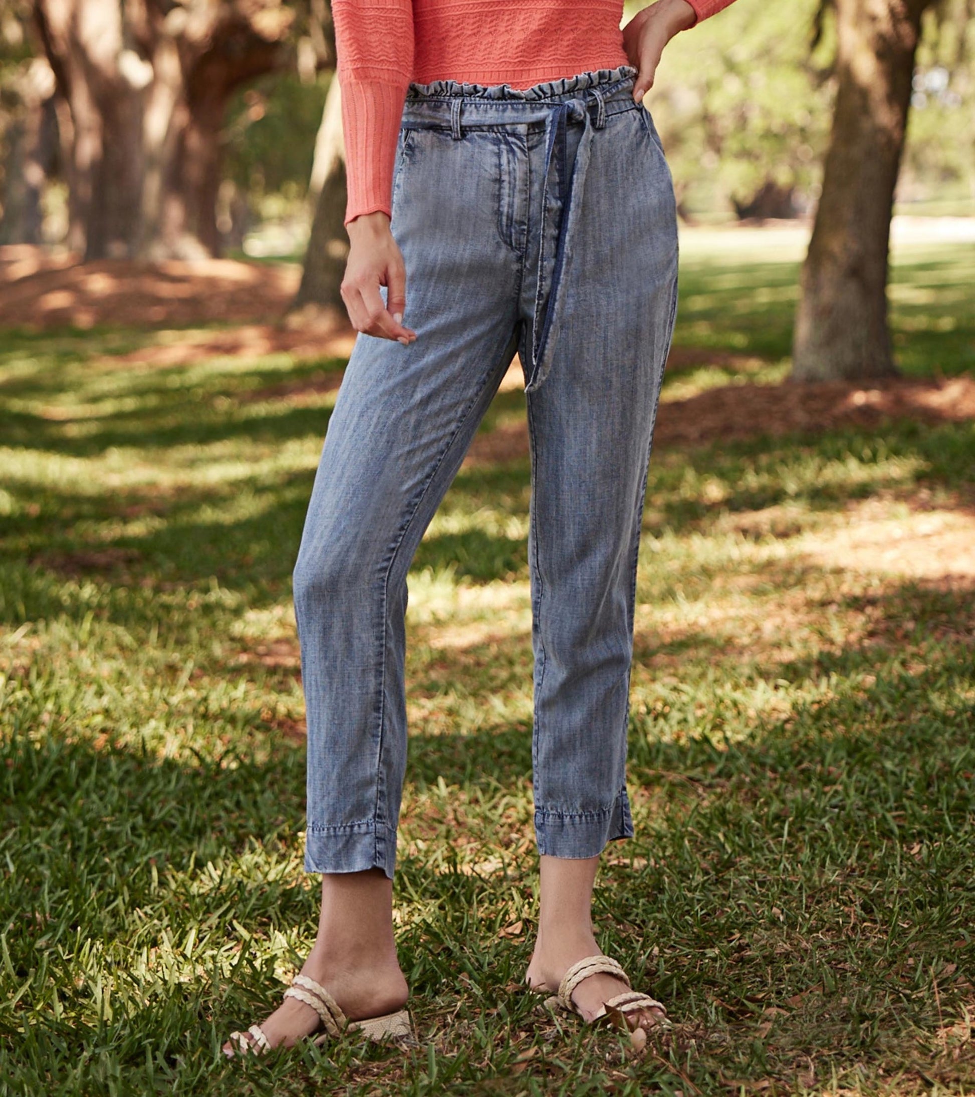 Blue acid rinse paper bag pants with a drawstring waist and tapered legs, styled for a casual outdoor look.