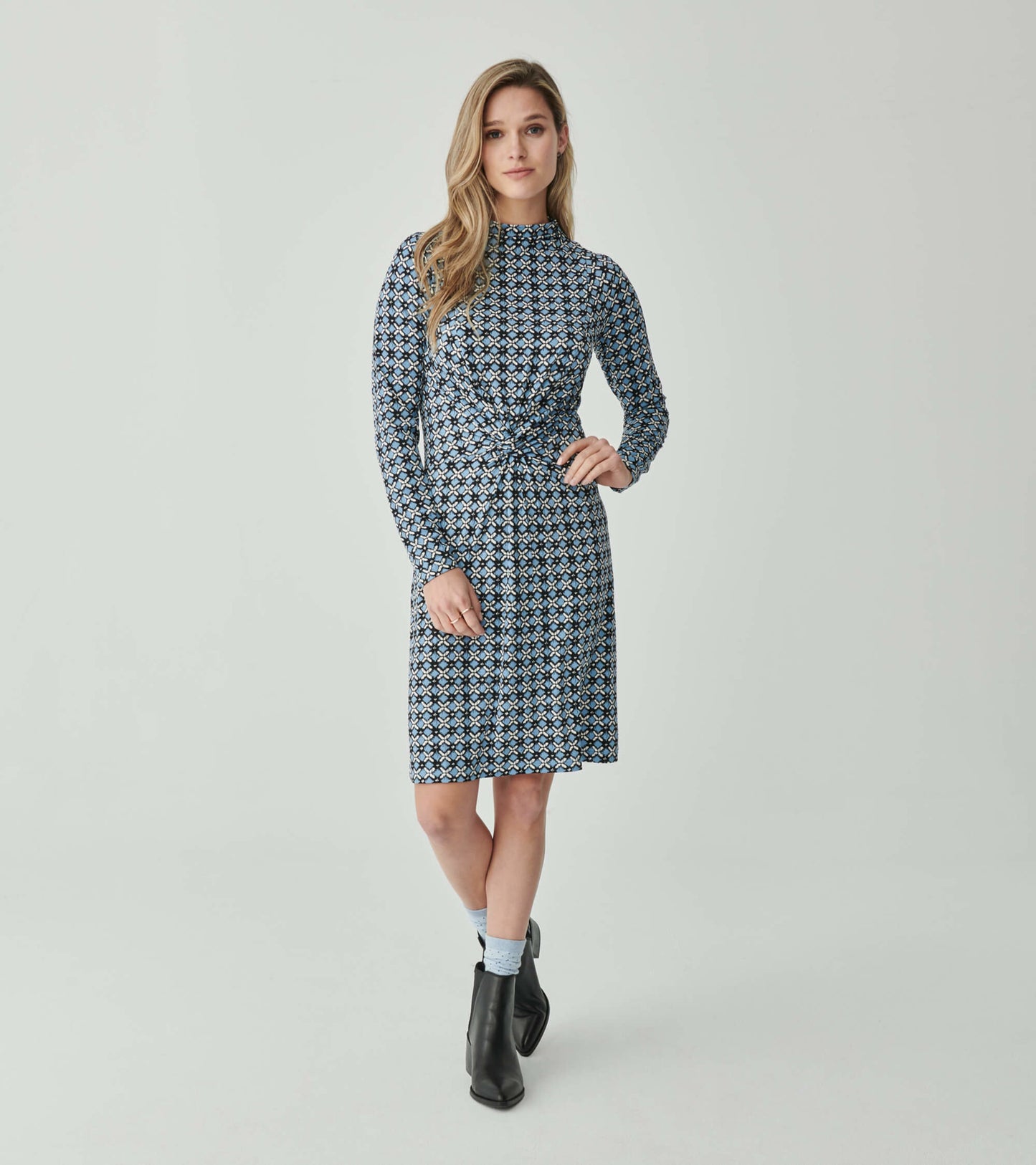 Long-sleeve dress featuring a blue ikat pattern with a knotted waist detail, suitable for casual or semi-formal wear.