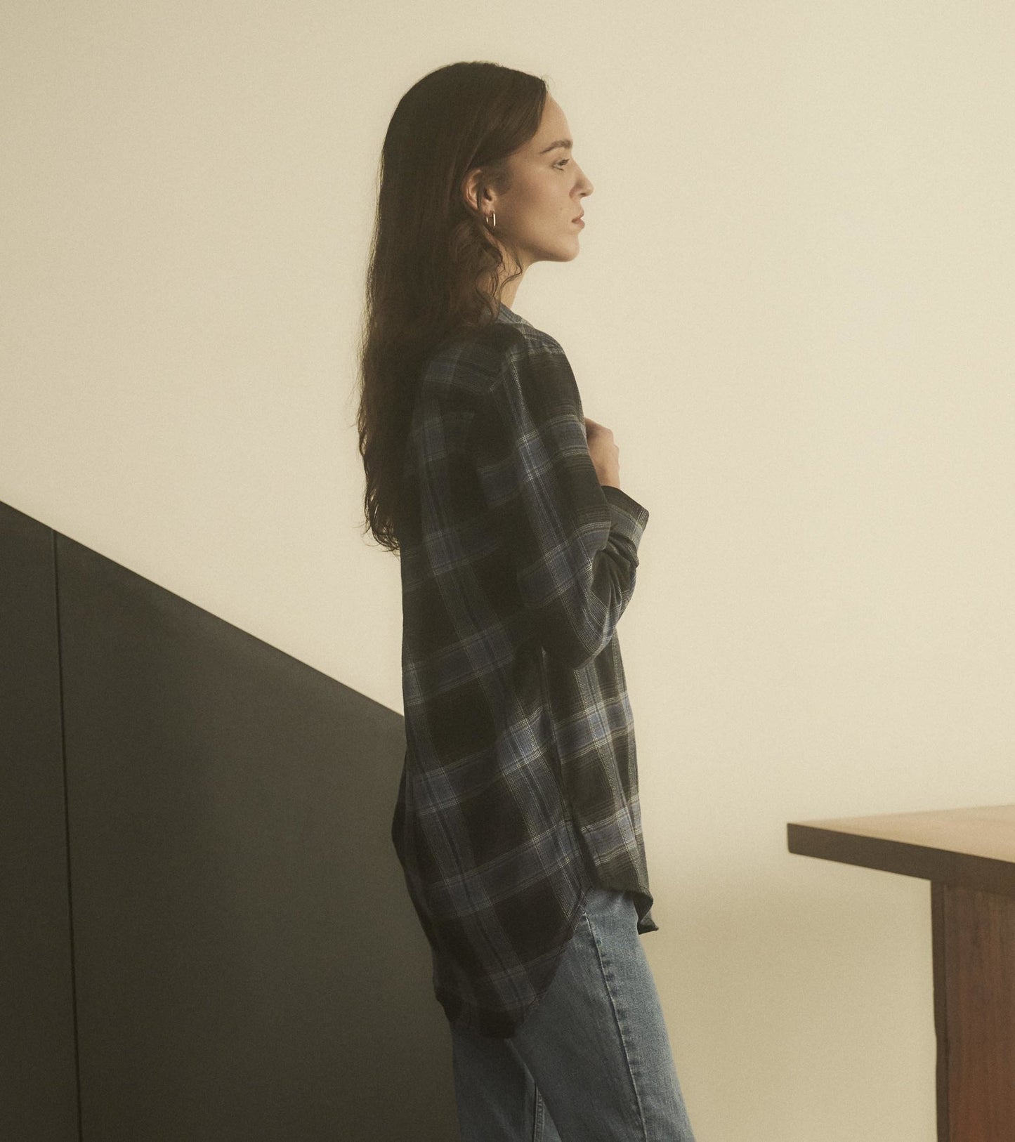 Caviar plaid tunic in black and blue, featuring a relaxed fit and longer back hem, styled with jeans.
