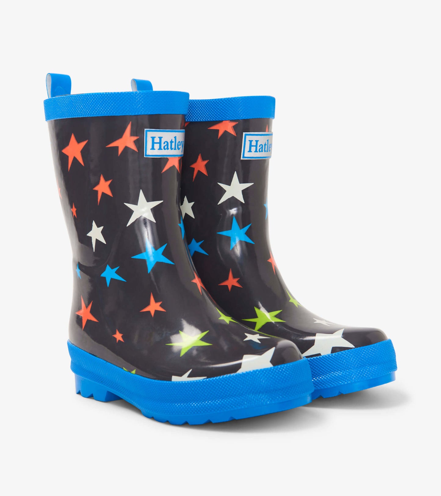Shiny black kids' rain boots with colorful star patterns and blue soles, featuring pull tabs for easy wear.