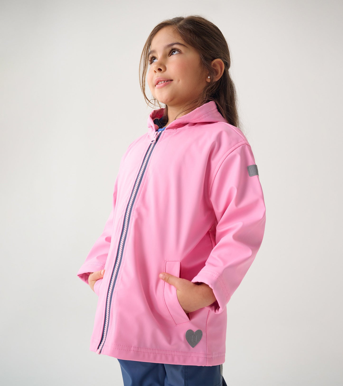 Classic pink zip-up rain jacket with a hood, featuring front pockets and a heart detail on the hem.