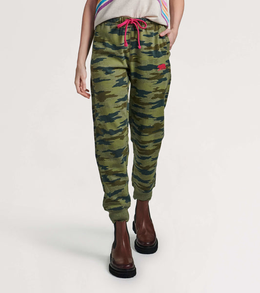 Green woodland camo joggers with a drawstring waist and side pockets, styled with a casual top and ankle boots.