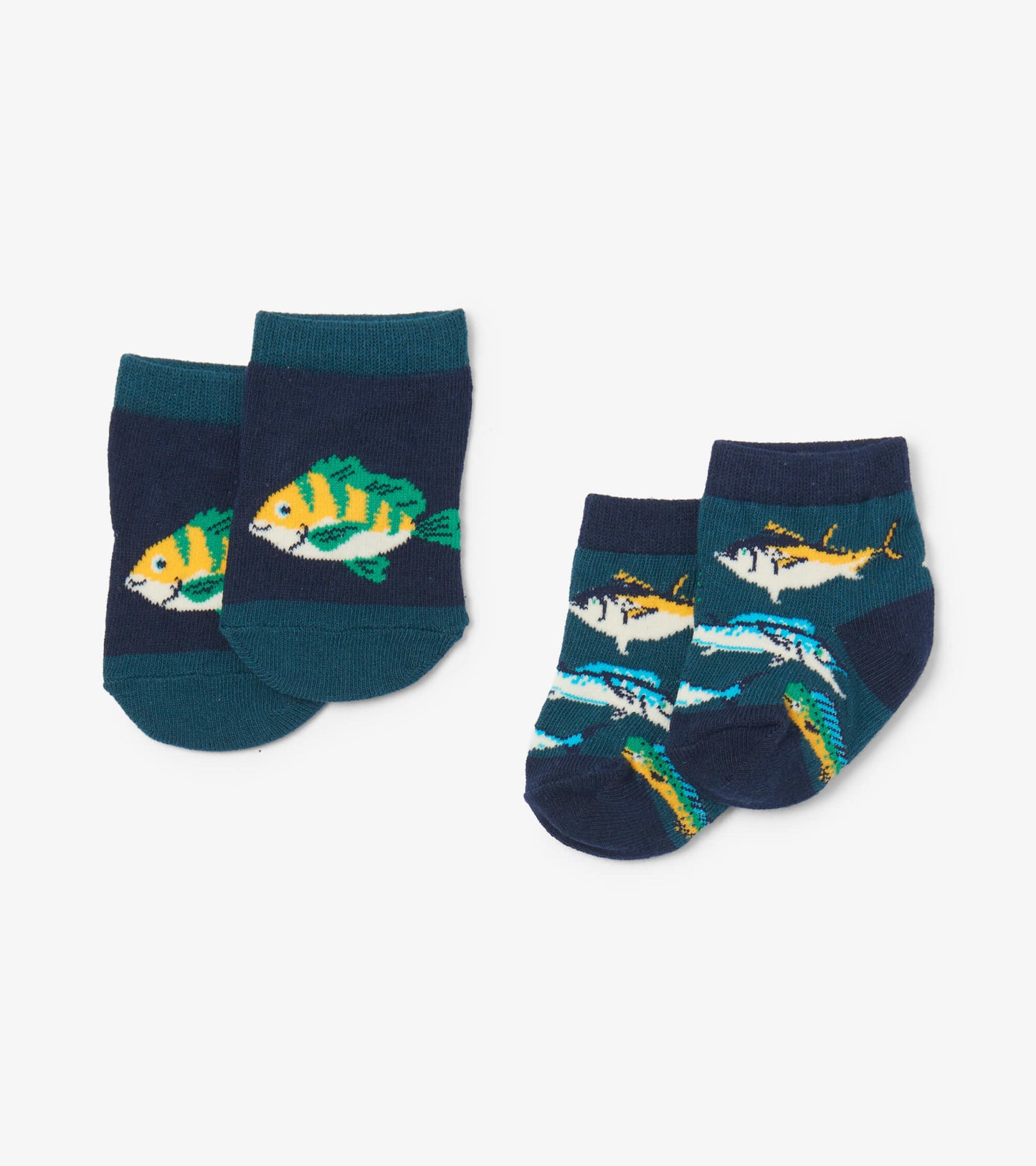 Two pairs of baby socks featuring colorful fish designs on a navy background, suitable for infants aged 0-24 months.