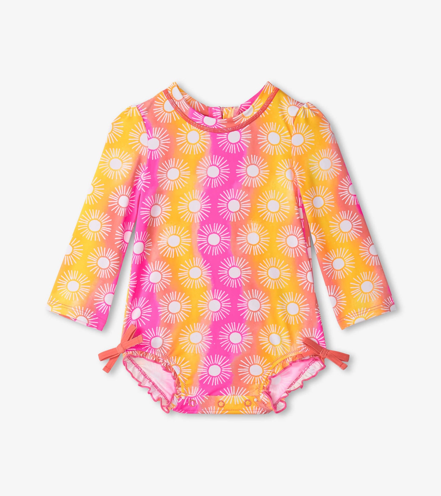 Long-sleeve baby swimsuit featuring a vibrant sun pattern in pink and yellow with side ties and ruffled edges.