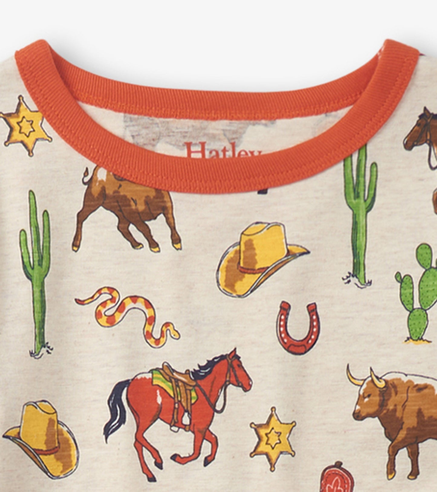 Beige pajama top featuring colorful vintage rodeo-themed illustrations, including horses, hats, and cacti, with an orange ne…