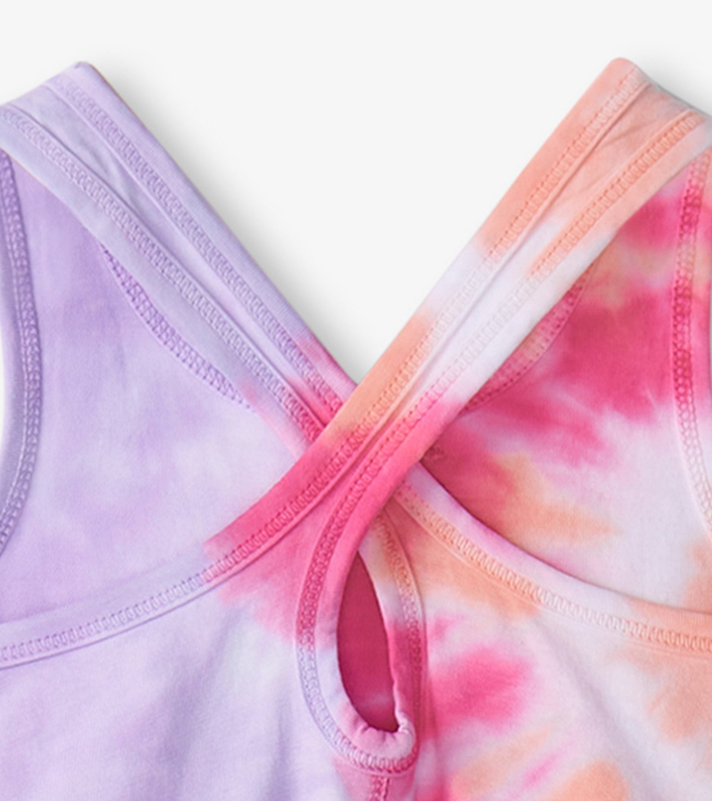Purple and pink tie-dye fabric with crisscross straps, showcasing a soft, lightweight summer dress design.