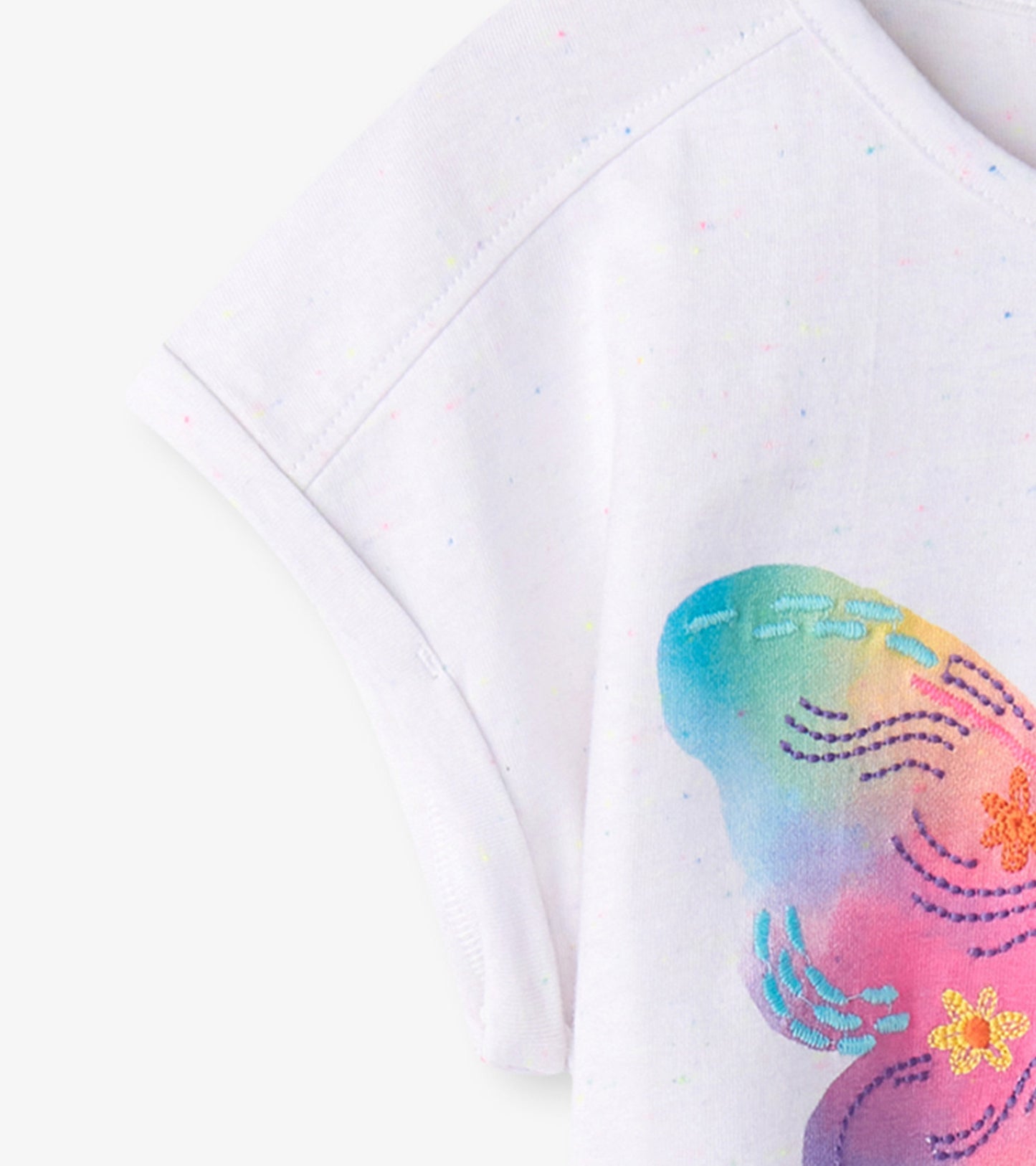 White relaxed t-shirt featuring a colorful painted butterfly design with pastel hues and subtle speckled texture.