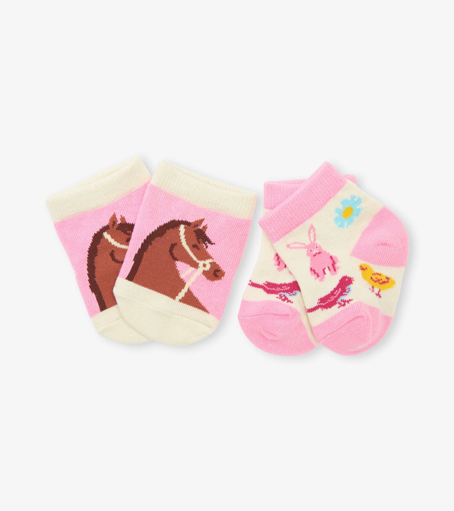 Two pairs of baby socks: one with a horse design on pink, the other featuring a bunny and flowers on cream and pink.