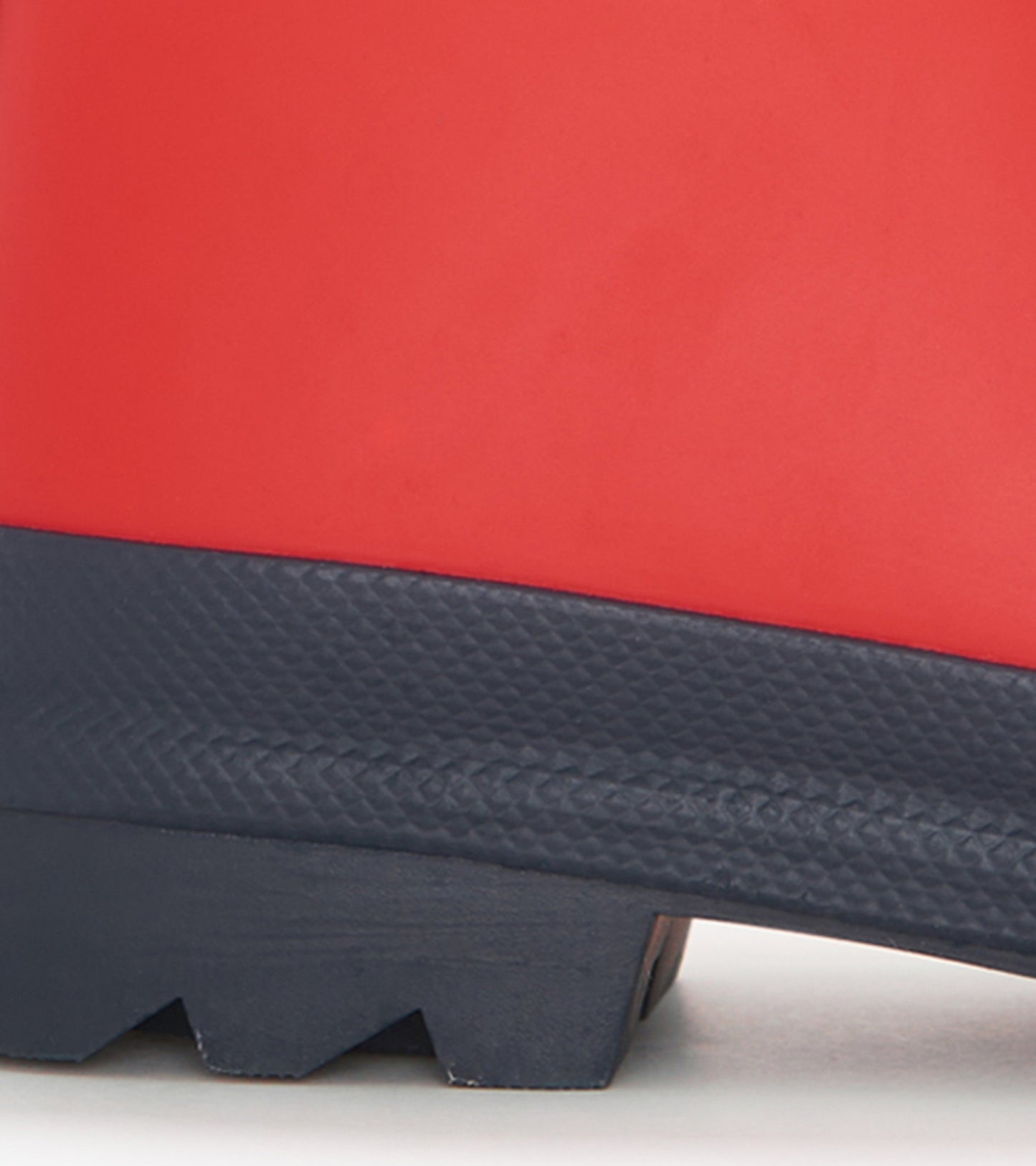 Red and navy matte rain boots with textured sole, designed for kids, ideal for wet weather.